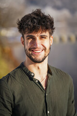 Fototapeta premium portrait of a young smiling man with dark hair and modern hair cut