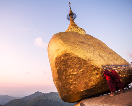 Two buddhist monks praying at the Golden rock, Myanmar
