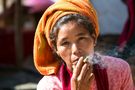 Asian woman smoking cigar, portrait. Myanmar