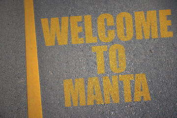 asphalt road with text welcome to Manta near yellow line.