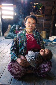 Chin woman with  traditional facial tattoo and her baby, Myanmar