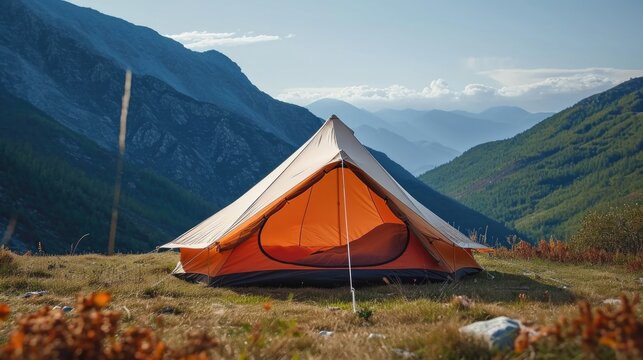 A tent pitched up in a field with mountains in the background