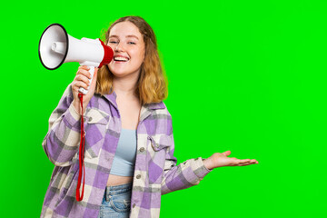 Happy caucasian woman talking with megaphone, proclaiming news, loudly announcing advertisement discounts sale, using loudspeaker to shout speech. Redhead girl isolated on green chroma key background