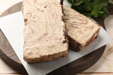 Pieces of tasty chocolate halva on wooden table, closeup