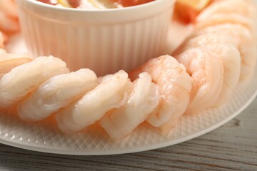 Fototapeta na wymiar Tasty boiled shrimps with cocktail sauce on white wooden table, closeup