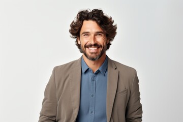 Portrait of a handsome man smiling at camera while standing against grey background