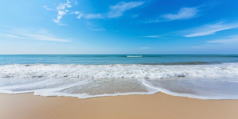 beach scene with gentle waves and a clear blue sky on a sunny day