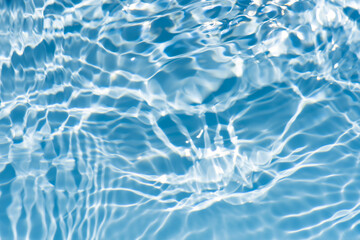 Bluewater waves on the surface ripples blurred. Defocus blurred transparent blue colored clear calm water surface texture with splash and bubbles. Water waves with shining pattern texture background.