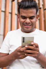 Latin Man with Braces Using Smartphone