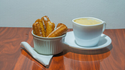 Delicious plate of churros and chocolate, traditional food dessert, sprinkled with sugar