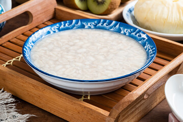 Sweet peanut soup with brown sugar bun cake in a bowlon the wooden table  