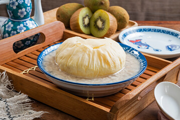 Sweet peanut soup with brown sugar bun cake in a bowlon the wooden table  