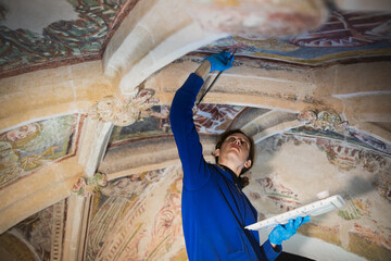Confident Female Expert in Antique Gothic Fresco Renovation on Work Under Church Ceiling