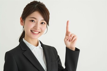 指をさす日本人の女性ビジネスマンウーマンのポートレート写真（白背景・会社員・スーツ・若手・OL・新入社員・窓口・案内）