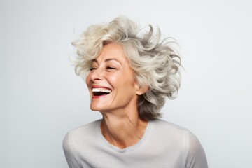 Portrait of a beautiful middle-aged woman laughing against white background