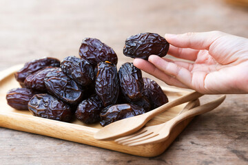 Dried Medjool dates held in the hands of a woman are a fruit rich in nutrients.