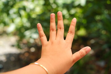 hand of a child on a green background. focus on the hand