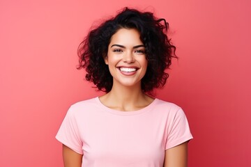 Portrait of a happy young woman looking at camera over pink background