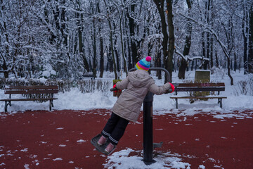 child playing sports in a public park in the winter.