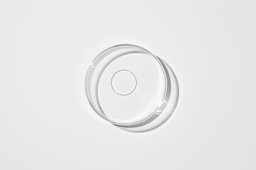 top view shot of a petri dish with liquid bubbles oil on a white background. hard lighting hard...