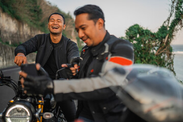 asiani rider holding phone and laughing about something on the phone with pointing gesture
