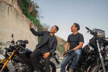 happy indonesian riders watching phone together while traveling together