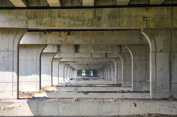 under toll road bridges or highways where there are many bridge pillars. perspective view.