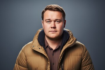 Handsome young man in warm jacket. Studio shot over grey background.