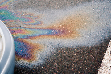 Oil stain or gasoline caused by a leak under a car. Environmental pollution concept.
