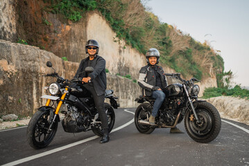 Fototapeta na wymiar indonesian men wearing jacket and helmet sitting on motorbike on the road