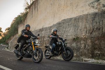Obraz na płótnie Canvas asian male riders riding motorbike down the road