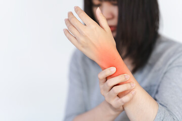 A woman touches a red area on her wrist to indicate the pain point.