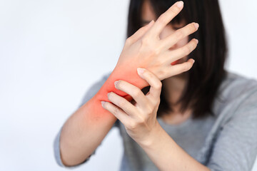 A woman's wrist is in pain and a red area is made to show the pain point. - obrazy, fototapety, plakaty