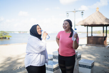 asian women standing and drinking mineral water in outdoors