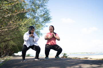 asian sporty women warming up doing squat pose together