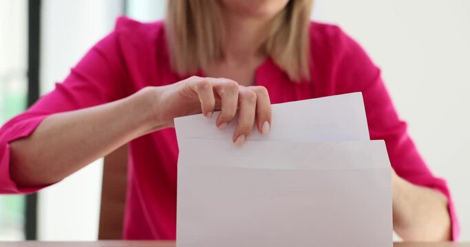 Female hands putting letter into an envelope in office