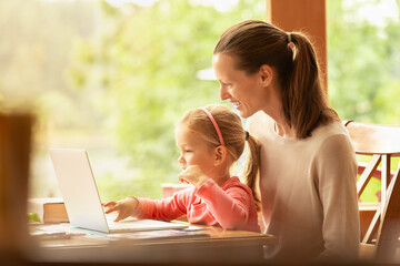 Happy parent and child using laptop