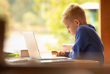 child working on laptop at home 