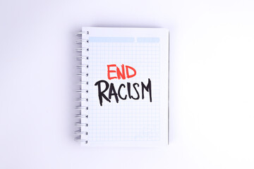 photograph of notebook with phrase "stop racism" on a white background.