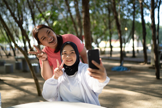 asian women in sportswear taking picture or selfie with phone