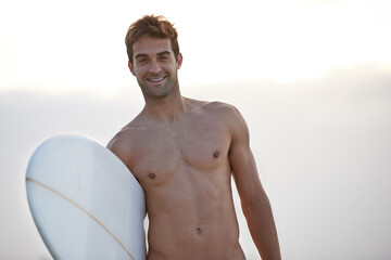 Fitness, portrait and happy man at a beach with surfboard for wellness, sports and training in nature. Water, exercise and face of male surfer at the ocean for morning cardio, freedom and travel