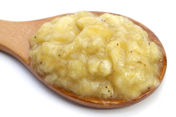 Mashed banana in bowl on white background.