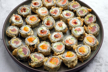 Assorted sushi nigiri and maki big set on round tray, top view.