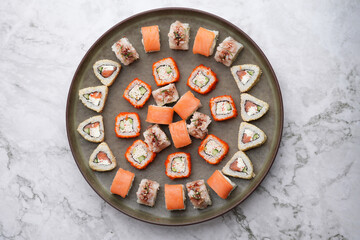 Assorted sushi nigiri and maki big set on round tray, top view.