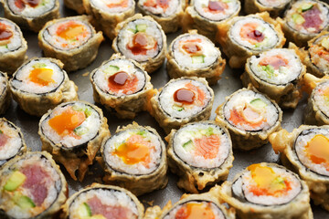 Assorted sushi nigiri and maki big set on round tray, top view.