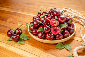 Red Cherry in wooden plate on wooden background, Cherry fruit in wooden basket on wooden table.