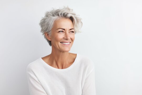 Portrait of happy senior woman looking at camera over white background.