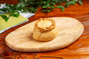 Pie with filling on a wooden board.