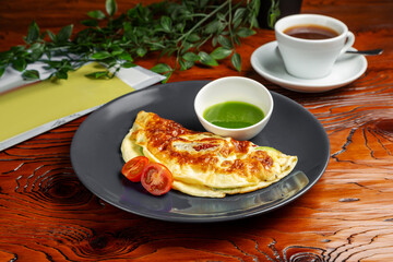 Egg omelet with tomato. Breakfast. On a wooden table.