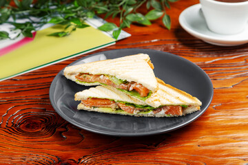 Salmon sandwich. Breakfast. On a wooden table.